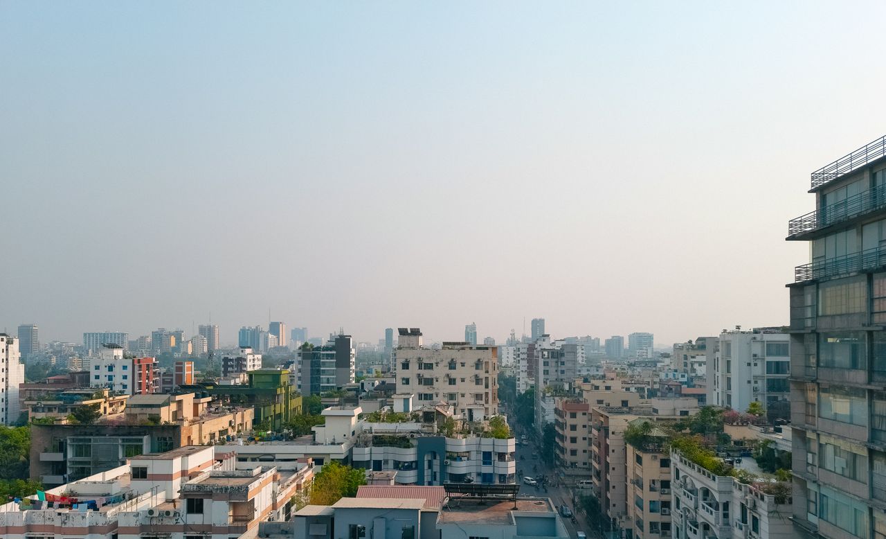 Captivating view of Dhaka's high-rise buildings under a foggy sky, showcasing modern urban architecture.